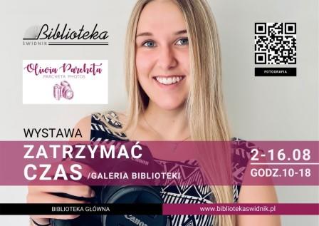 na plakacie uśmiechęta dziewczyna trzymająca aparat